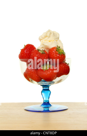 Cornish fraises et crème caillée dans un sundae verre sur une surface en bois sur un fond blanc. Banque D'Images