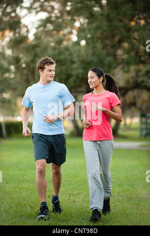 Jeune couple jogging sur l'herbe Banque D'Images