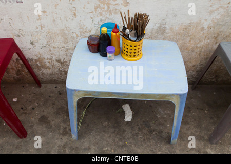 Les ustensiles et les condiments sur table en sidewalk cafe Banque D'Images