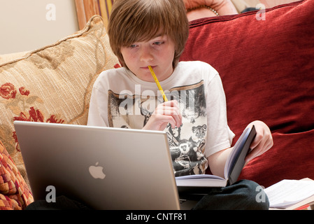 Jeune homme garçon faire ses devoirs Banque D'Images