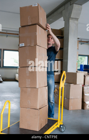 L'empilement des boîtes de carton Man sur dolly Banque D'Images