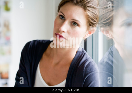 Close up of woman leaning on window Banque D'Images