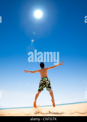 Happy young man jumping on the beach Banque D'Images