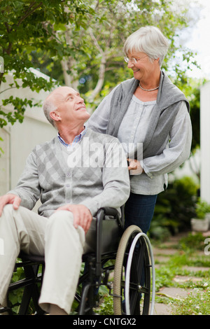 Wheeling infirmière patient plus âgé à l'extérieur Banque D'Images