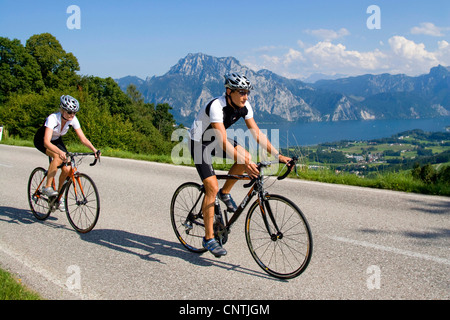 L'homme et de la femme avec les vélos de course sur un tour dans les Alpes, montagnes, avec le lac Traunsee derrière, l'Autriche, Haute Autriche, Gmunden Banque D'Images