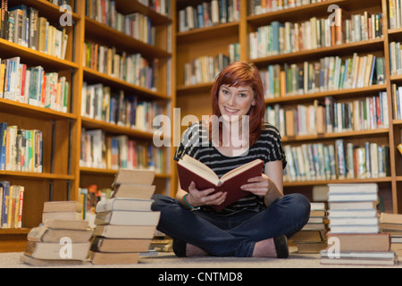 Élève de pile of books in library Banque D'Images