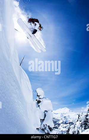 Skier jumping on snowy slope Banque D'Images