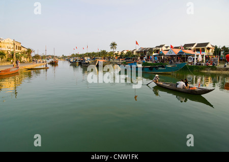 Vue horizontale de la pêche traditionnelle des bateaux sur l'estuaire de la rivière Thu Bồn circulant dans le centre de Hoi An, ville ancienne. Banque D'Images