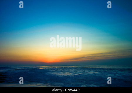 Voir après le coucher du soleil à l'heure bleue à partir de la mer du Nord tidelands à marée basse sur la mer, l'ALLEMAGNE, Basse-Saxe, Landkreis Cuxhaven, Cuxhaven Banque D'Images