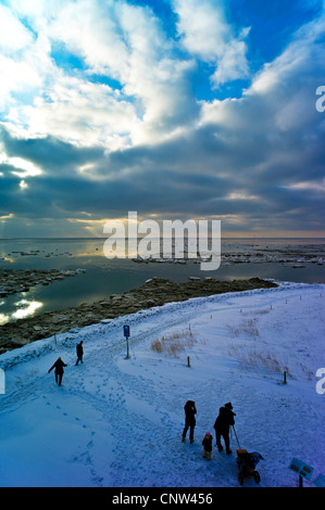 Les gens à la rive couverte de neige à l'entrée du port avec vue sur le chenal de navigation d'Aussenweser, ALLEMAGNE, Basse-Saxe, Landkreis Cuxhaven, Wremertief Banque D'Images