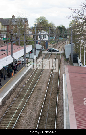 Highams Park Station de passage à niveau et de la plate-forme du nord-est de Londres, Royaume-Uni, avec des lignes de passage de voiture et le signal fort en arrière-plan Banque D'Images