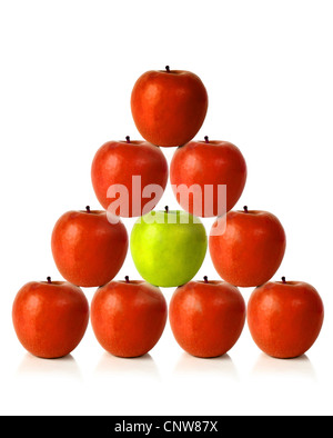 Pommes rouges sur une forme de la pyramide avec une pomme verte au milieu, être différent Banque D'Images