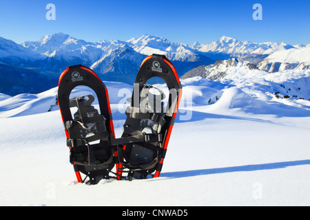 Paire de chaussures neige bloqué dans un champ de neige dans les Alpes valaisannes en face de Weissmies (4023 m), Fletschhorn (3992 m), l'Alphubel (4206 m), le Dom (4545 m), Mischabelhorns, Matterhorn (4477 m) et Weisshorn (4505 m), Suisse, Valais Banque D'Images