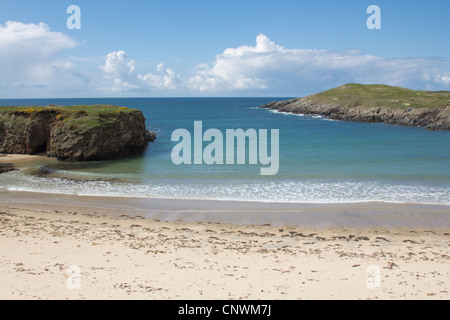 Des eaux bleu azur de la baie de câble, au large de l'Anglesey Sentier du littoral, sur une journée ensoleillée d'avril. Banque D'Images