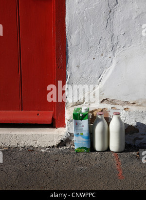 Les bouteilles de lait et la boîte porte la livraison Banque D'Images