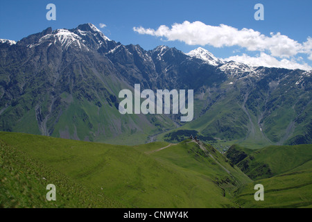 Vue sur la vaste vallée, Tsiminda Sameba église dans l'avant-plan, la ville Stepantsminda dans la vallée, près de quatre-mille en arrière-plan, la Géorgie, l'Mzcheta-Mtianeti Qasbegi Stepanzminda,, Banque D'Images