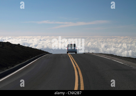 Voiture voyageurs sur une route sur les nuages au sommet du volcan Haleakala (3000 m), USA, Hawaii, Maui Banque D'Images