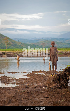 Les garçons la pêche dans un petit lac au bord d'une plantation, Burundi, Rumonge, Rumonge Banque D'Images