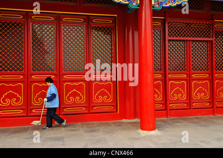 Un préposé balaye la poussière de la cour pavée de la Cité interdite à Pékin, Chine Banque D'Images