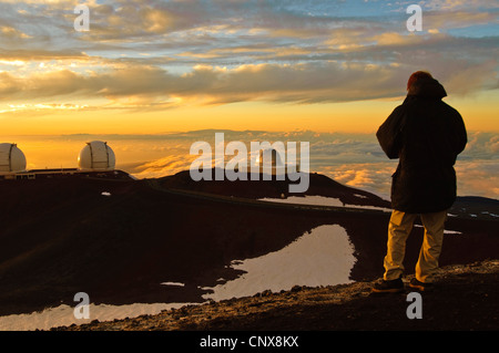 Homme qui regarde l'observatoire astronomique sur le mont Mauna Kea à Hawaii, USA, coucher du soleil Banque D'Images