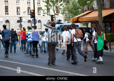 Rollers en passant le long d'une rue à Paris un dimanche après-midi. Banque D'Images