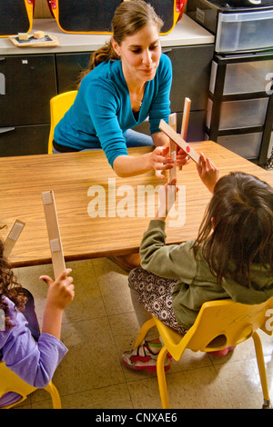 L'enseignant dans une classe d'écriture Braille préalable à l'apprentissage des enfants aveugles Center démarre le morceau de taraudage. Banque D'Images