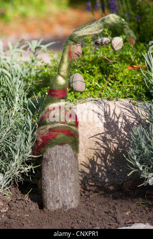 Pierre se sentait 'troll' servant de décoration de jardin : une pierre naturelle équipée de bouchons de laine feutrée est debout dans un lit de fleur, Allemagne Banque D'Images