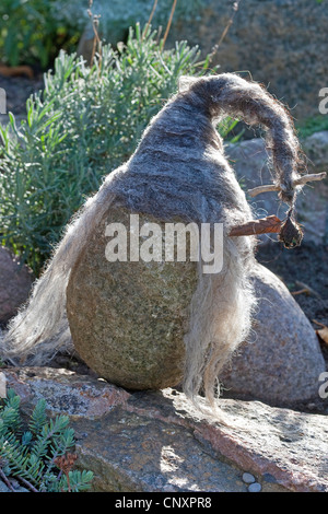 Pierre se sentait 'troll' servant de décoration de jardin : une pierre naturelle équipée de bouchons de laine feutrée est debout dans un lit de fleur, Allemagne Banque D'Images