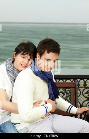 Gay man hugging son amant sourire rêveur Banque D'Images