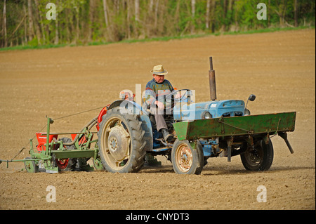 Agriculteur sur un tracteur labourant son acre, Autriche Banque D'Images