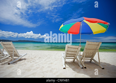 Chaises en toile et un parasol sur une plage de sable, Philippines Banque D'Images