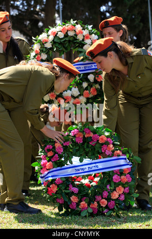 Femmes soldats israéliens portent des couronnes au cours d'une cérémonie commémorative en l'honneur des soldats sur Yom Hazikaron Memorial Day pour les soldats tombés à Kiryat Shaul cimetière juif dans le nord de Tel Aviv, Israël Banque D'Images