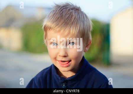 A cute kid (4-5) est souriant à l'extérieur. Banque D'Images