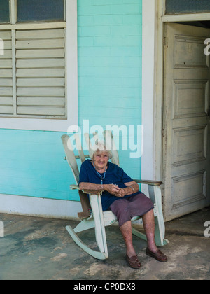 De 70 à 80 ans, une femme hispanique cubain avec les cheveux gris est assise sur son fauteuil à bascule sur son porche à Viñales, Cuba. Banque D'Images