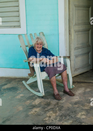 De 70 à 80 ans, une femme hispanique cubain avec les cheveux gris est assise sur son fauteuil à bascule sur son porche à Viñales, Cuba. Banque D'Images