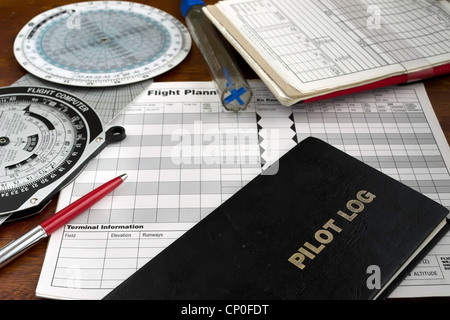 Journal pilote sur une table en bois avec casque, testeur de carburant et traceur Banque D'Images