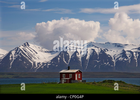 Chalet en bois sur les rives de l'Eyjafjordur avec les montagnes derrière Kaldbakur, près de Dalvik, le centre-nord de l'Islande Banque D'Images