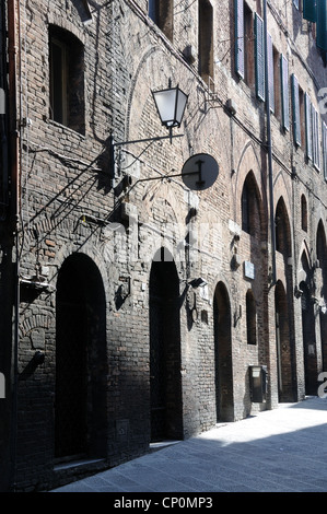 Lumière sur de vieilles briques apparentes sur la Via dei Rossi, à Sienne, Toscane, Italie Banque D'Images