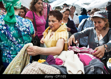 Les femmes de la classe moyenne mexicaine désireux d'une bonne affaire découvrez tas de vêtements au marché aux puces le week-end dans le quartier Roma Mexico City Banque D'Images