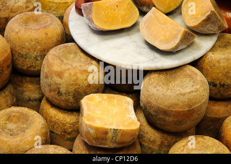 Ancien ensemble de fromage Gouda au comptoir et coupé en pièces enveloppées lying on a plate Banque D'Images