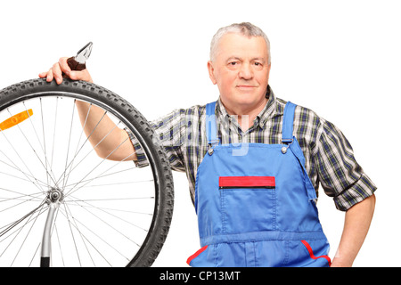 Les hommes d'âge moyen d'une pince et la réparation de la roue de bicyclette isolé sur fond blanc Banque D'Images