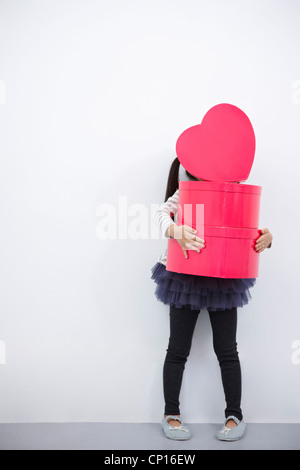 A girl holding boîte coeur rouge Banque D'Images