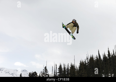 Snowboarder saute un gros kicker dans un parc acrobatique sur Whistler Blackcomb, British Columbia, Canada Banque D'Images