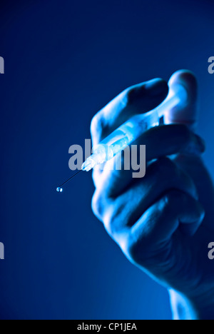 Libre d'une main tenant une seringue. Banque D'Images