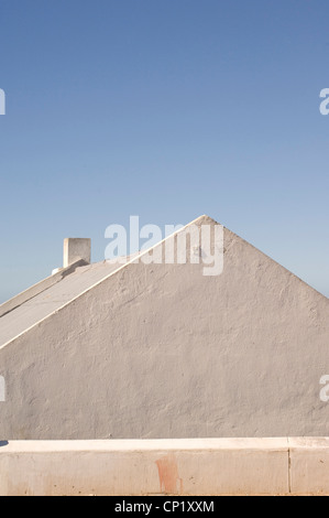 Blanchies à la chaux, toiture inclinée contre ciel bleu clair Banque D'Images