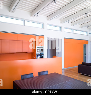 Cuisine ouverte, salle à manger, salle de séjour avec des murs orange et de ligne windows claire-voie. Banque D'Images