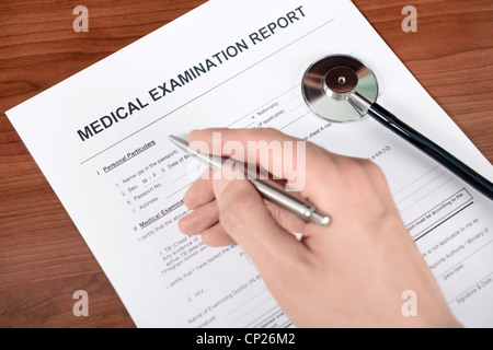Médecin remplit un formulaire de rapport médical vierge. Banque D'Images