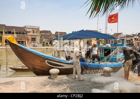 Les pêcheurs ayant tendance à leurs filets à côté de leur bateau, la rivière Thu Bon, Hoi An, Quang Nam Province, Vietnam Banque D'Images