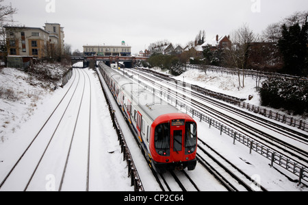 Metropolitan Line train de tube faire son chemin dans Londres au cours de la neige Banque D'Images