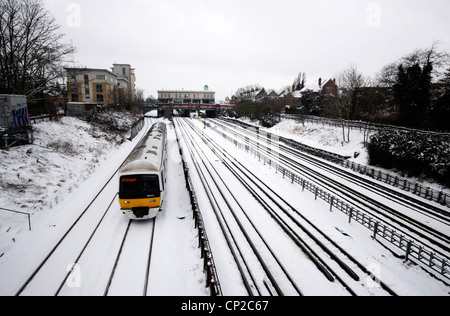 Train de banlieue faire son chemin dans Londres au cours de la neige Banque D'Images